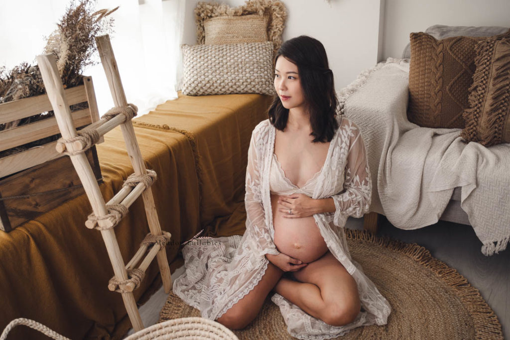 Maternity photography sit down pose in rustic decor