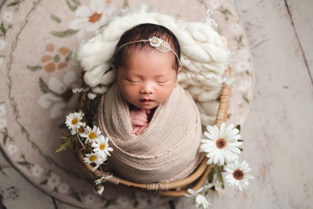 Newborn Photography Singapore newborn baby with flowers in rustic wooden basket