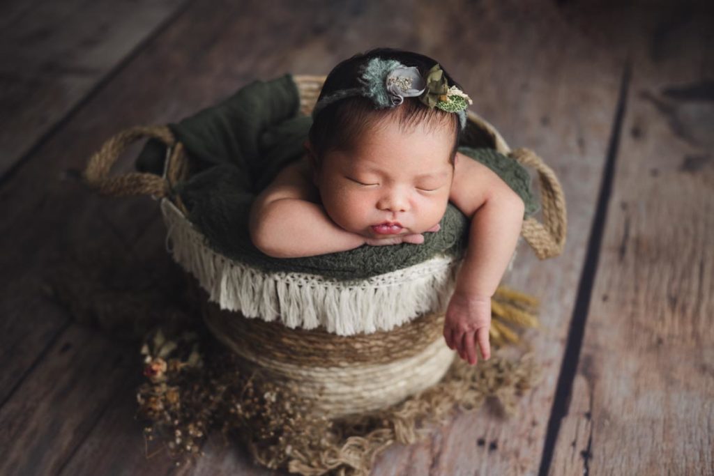 Newborn Photography Singapore newborn baby with flowers in rustic tassel basket