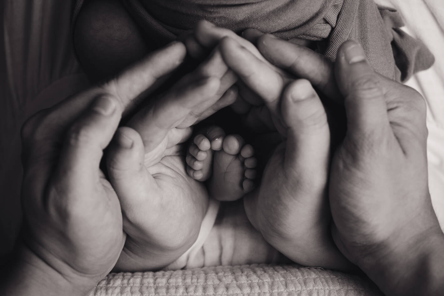 Closeup shot of newborn baby's feet with parents hand surrounding it