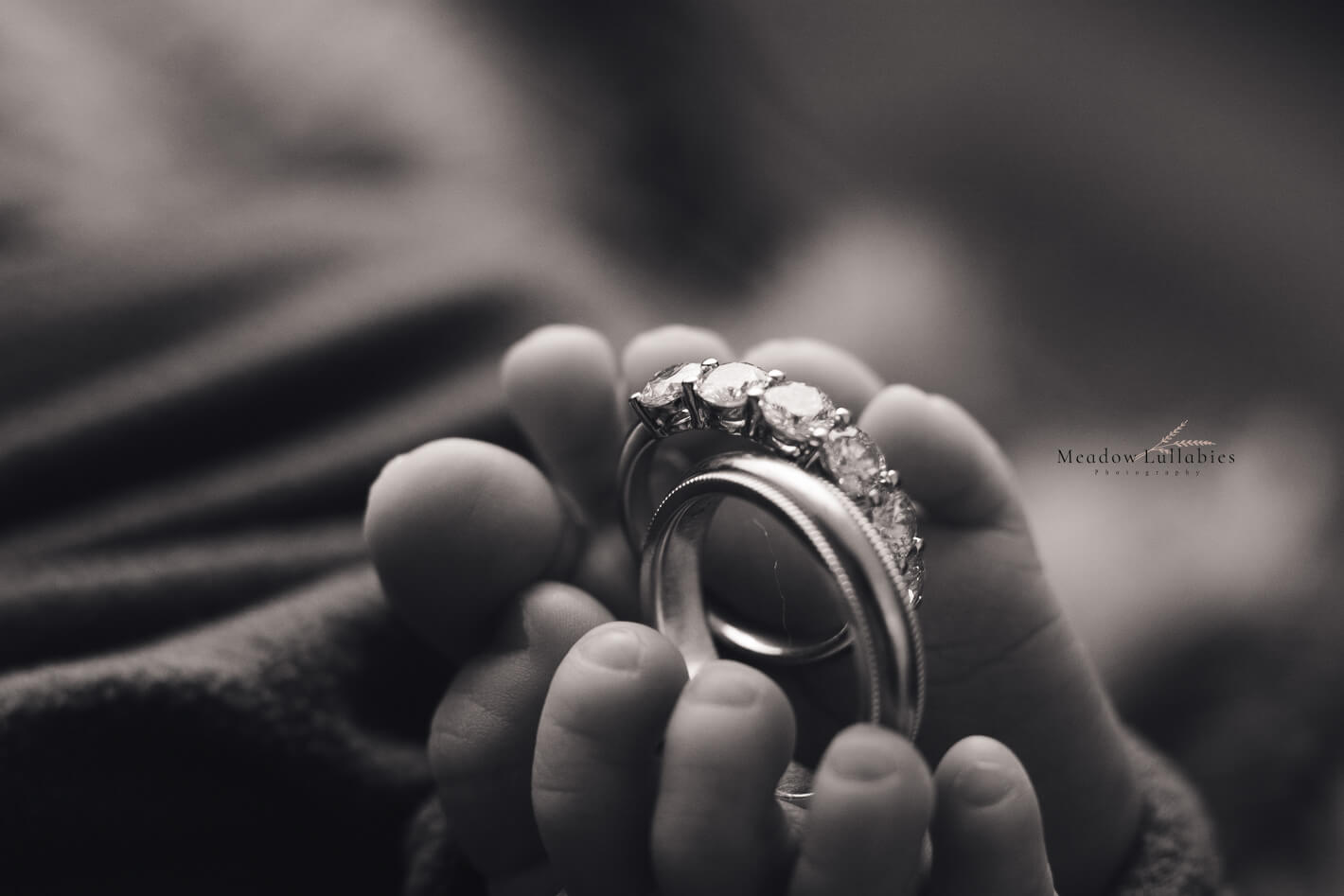 Close-up shot of parents wedding rings in newborn baby's feet