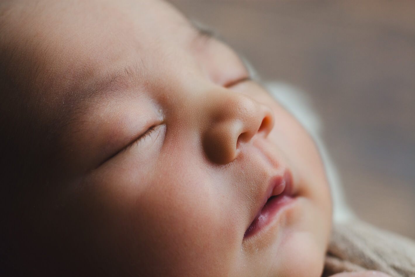 Intimate angled close-up of a newborn baby's serene sleeping face, newborn photography Singapore