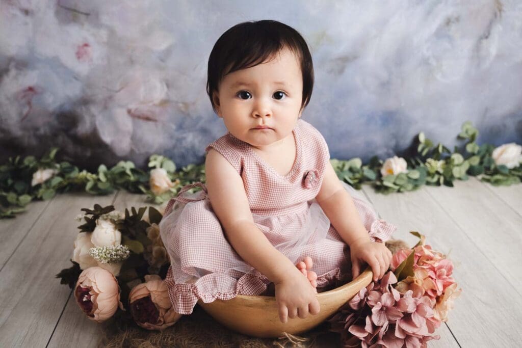 Cute mixed baby with floral backdrop