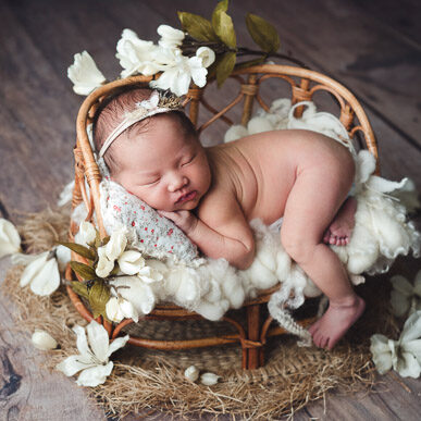 Naked newborn photography in rustic floral setup