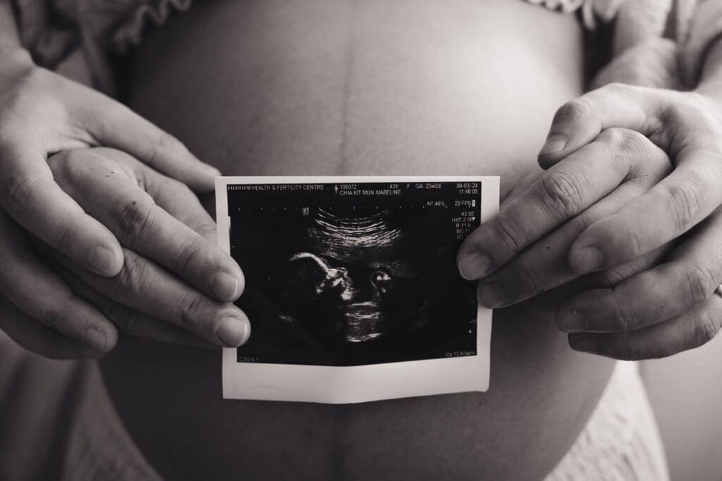 Maternity photography Singapore Maternity photoshoot couple holding ultrasound film