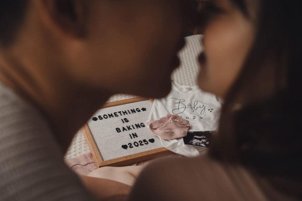 Pregnancy announcement board - shooting through couples face