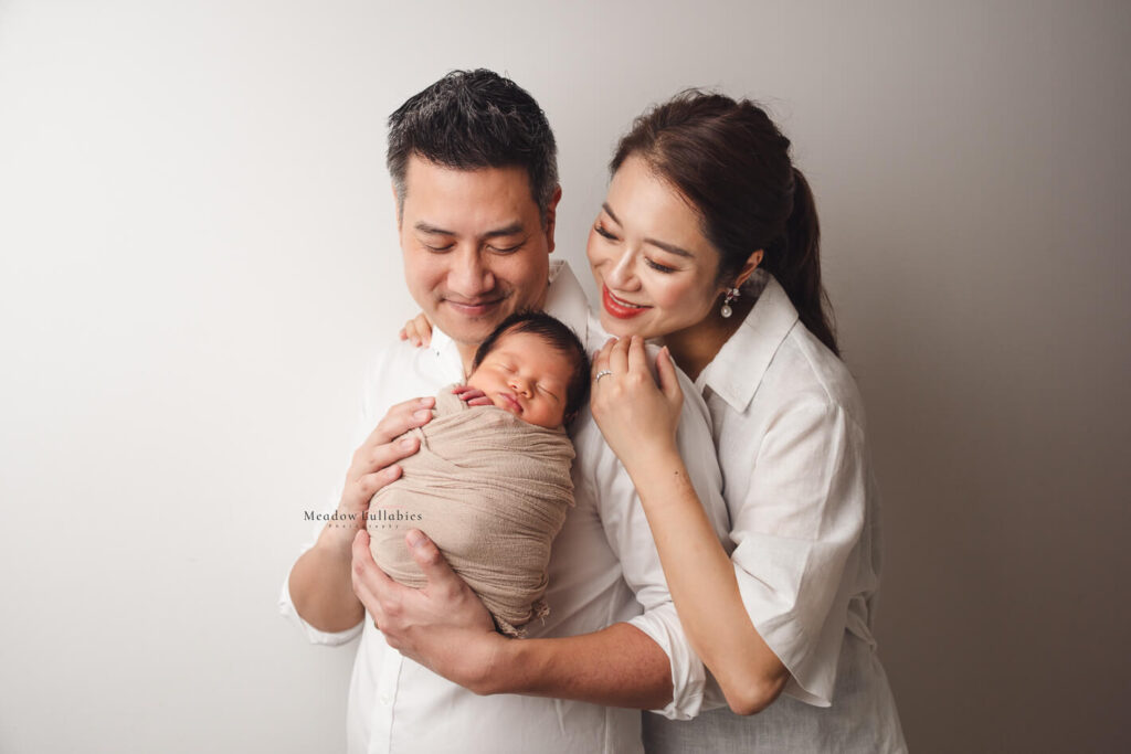 Newborn Photography Singapore Newborn photoshoot parents happily smiling at their newborn baby