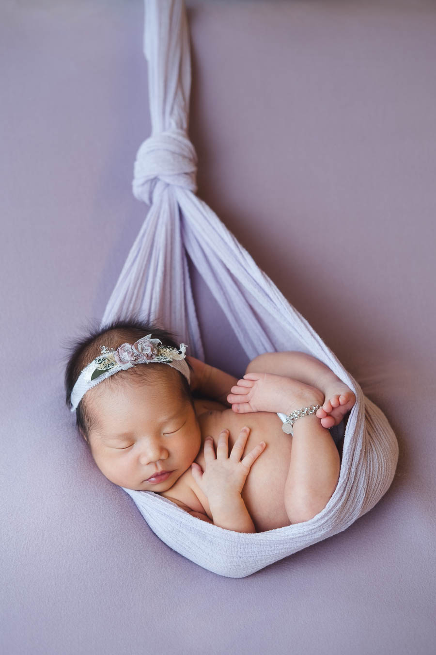Newborn baby in a suspended pose, newborn photography Singapore