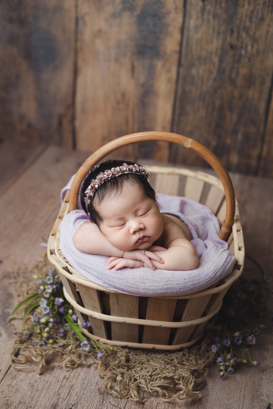newborn-sleeping-in-vintage-flower-basket-with-lavenders