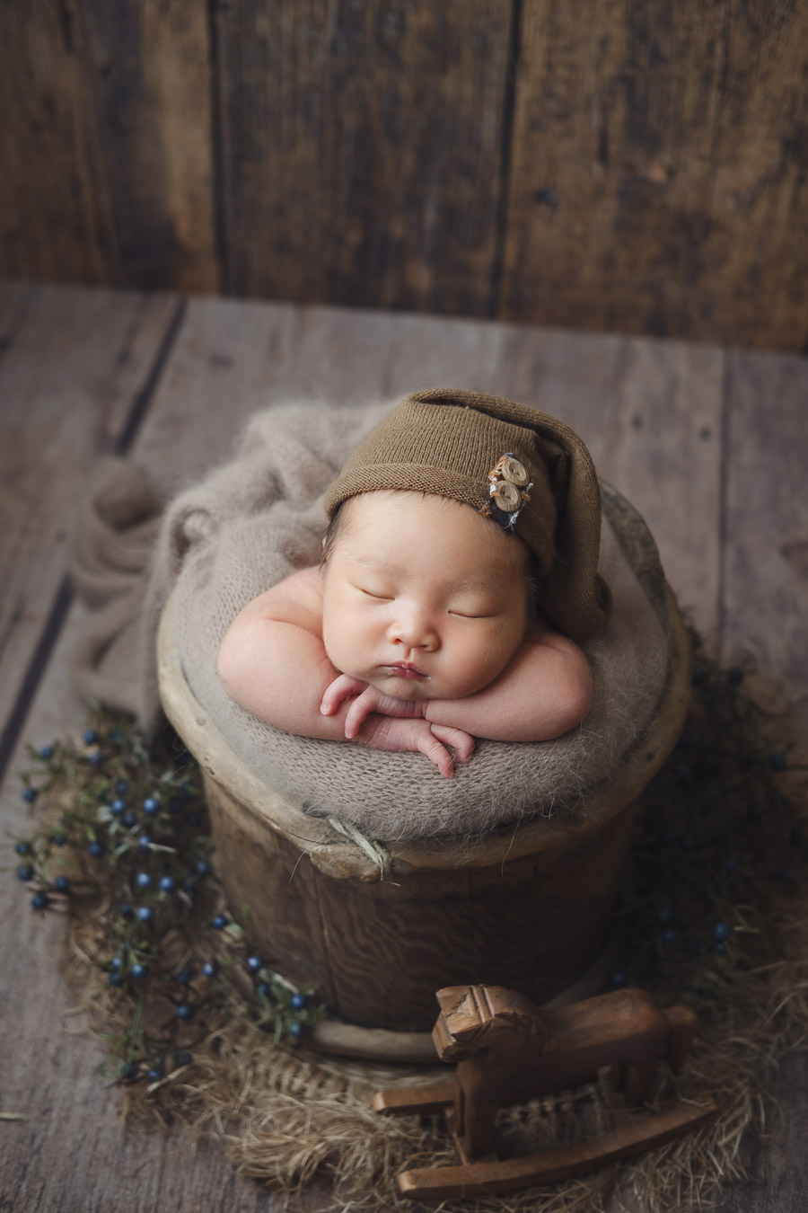 Neutral tone newborn baby boy posing in tibet bucket prop